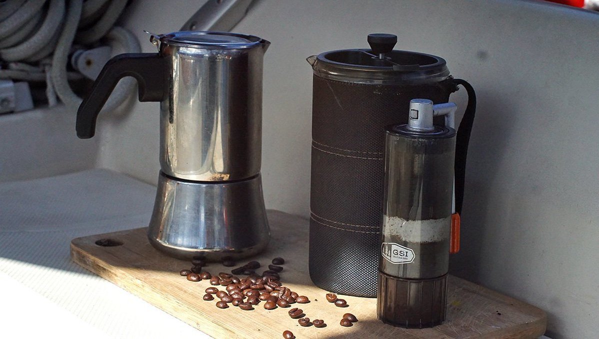 Our coffee accessories A photo of a mokapot, a french press and a coffee grinder, outside