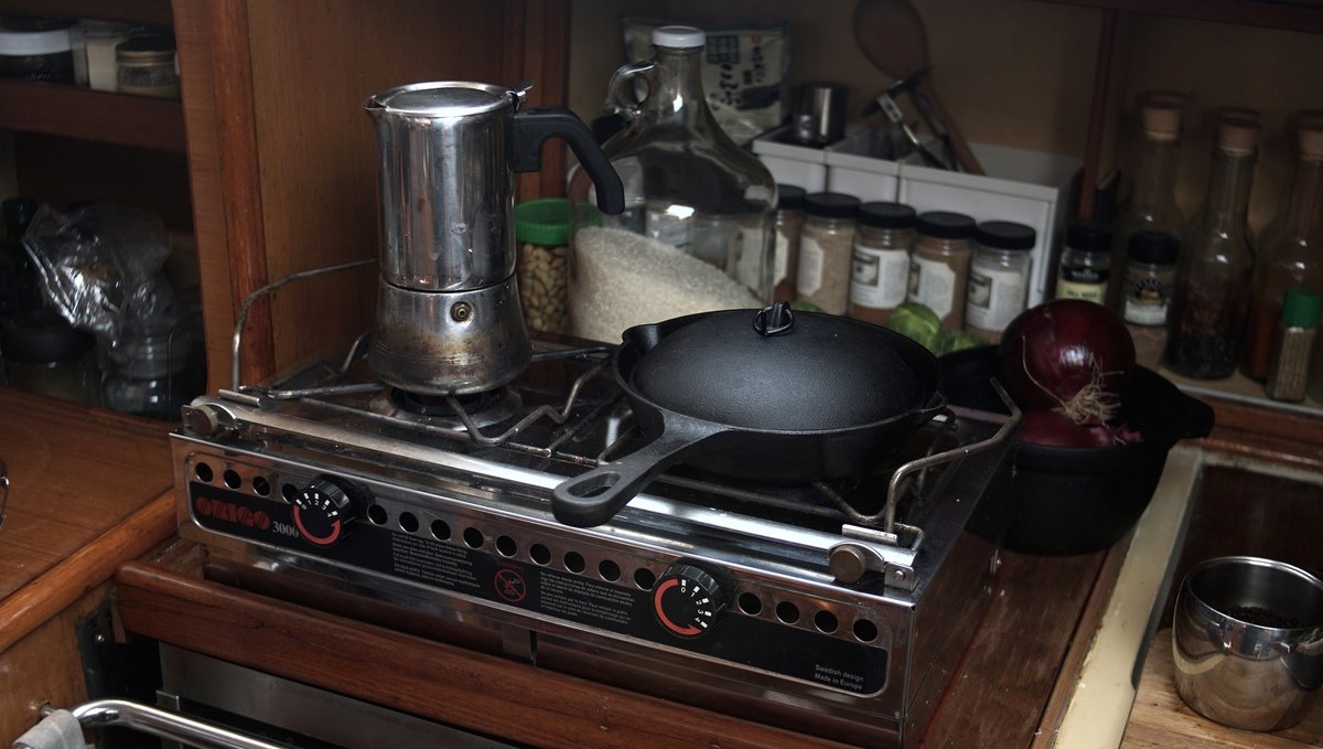 A two-burner Origo 3000 alcohol stove An Origo alcohol stove in a sailboat galley, there is a moka pot and a cast-iron pot overtop