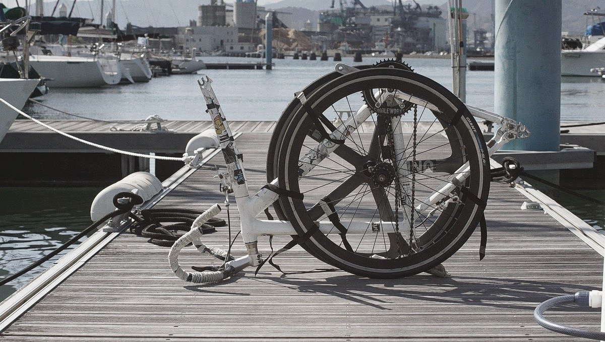 A bike ready for storage a bike on a marina dock with the two wheels off and strapped to the frame