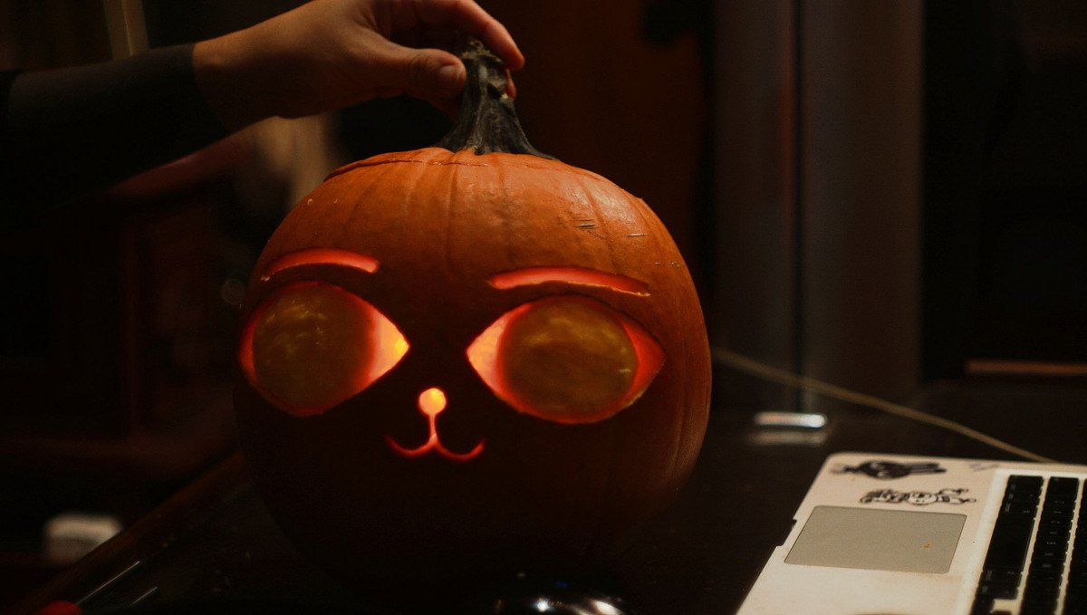 Catsoup pumpkin A photo of a candle-lit carved pumpkin with a cat face