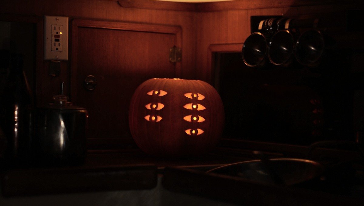 evangelion pumpkin A photo of a candle-lit carved pumpkin with 3 eyes aligned vertically with 4 eyes next to those for an assymetric look