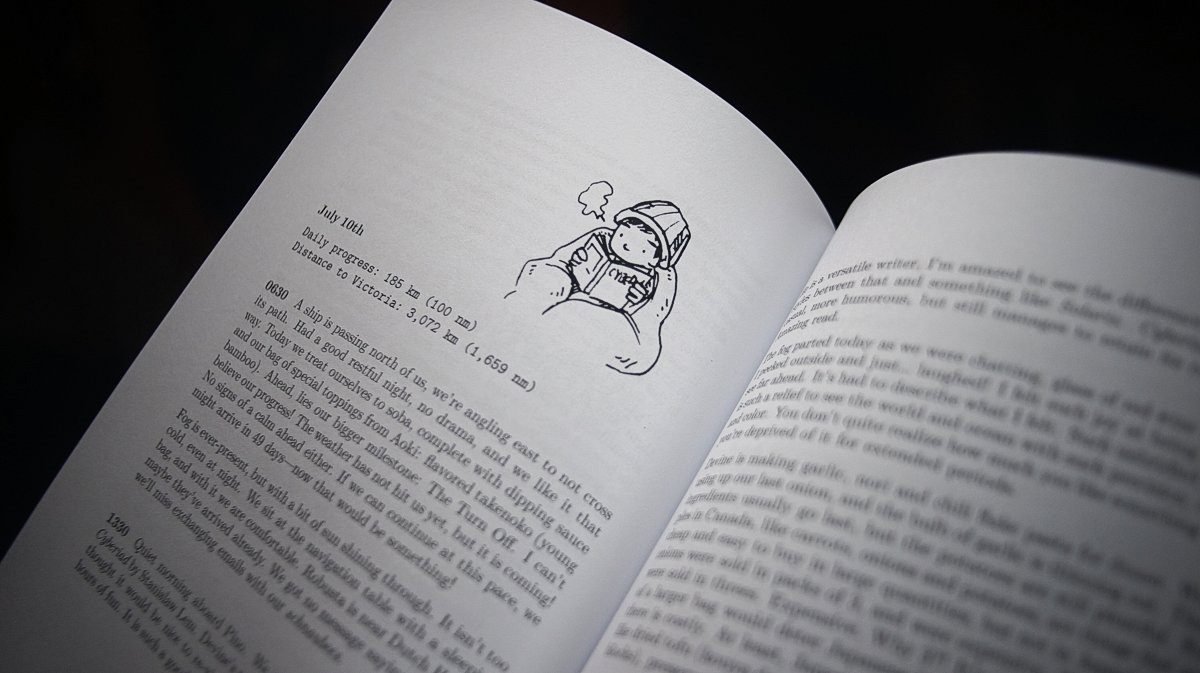 A look inside the book A paperback book is opened to a page featuring an illustration of Devine reading while wrapped in blankets