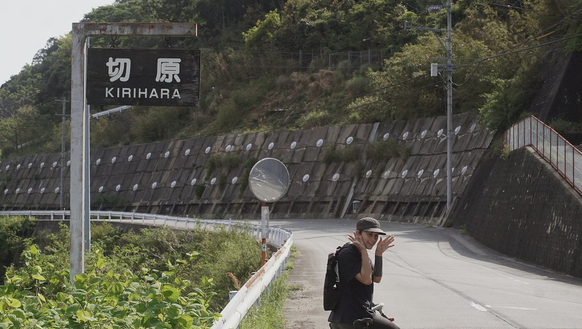 biking to Kirihara a photo of a road with rek on a bike beneat a side reading Kirihara