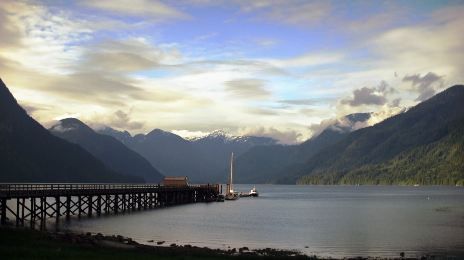 pino at a dock in shoal bay, with mountains towering in the background
