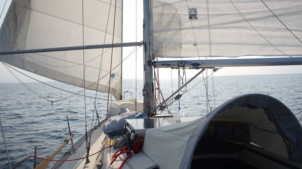 Pino sailing downwind, wing on wing in smoke