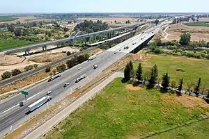 The same viaduct completed in April 2021. Adjacent are the SR&nbsp;99 freeway and, between them, a single-track railroad line which is used for freight.