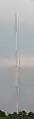 An antenna tower stands 446 feet (136&nbsp;m) tall in Springfield, MO with its red and white aircraft warning paint visible