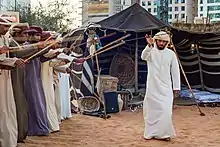 Image 16A band performs the Ayyala, which is a cultural dance derived from Arab tribes sword battles. (from Culture of the United Arab Emirates)