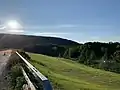 The back of the DeRuyter Reservoir dam in summer 2020, construction is ongoing