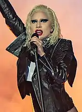 A woman with yellow hair, wearing a black bikini-shaped outfit.