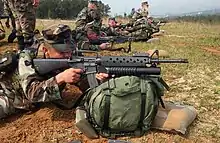 A U.S. Marine takes aim with an M16A2 fitted with the M203 40&nbsp;mm grenade launcher.