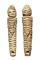 Statuette with hooded, decorated, overall.