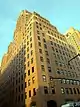 BellTel Lofts, a high-rise clad in yellow stone in an art deco architectural style, viewed from street level