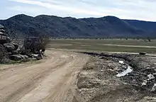 Photograph of deep ruts left by a vehicle that left a posted trail