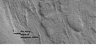 Close-up of pits forming along the edges of polygons in patterned ground, as seen by HiRISE under the HiWish program.  Resolution is about 30&nbsp;cm, so one could see a kitchen table if it were in the picture.