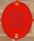 Oval red plaque bearing the words "In memory of District Officer Charles Pearson of the London Fire Brigade who died from injuries received at 100 Sidney Street near this site during the siege of Sidney Street on the 3rd of January 1911."