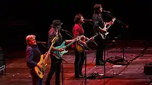 The Doobie Brothers performing in 2017.Left to right: touring member John Cowan, Patrick Simmons, Tom Johnston, and John McFee.