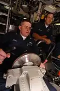 YN3 Joshua Jones, helmsman of the watch, maintains course and depth of USS&nbsp;Henry M. Jackson (SSBN-730). Diving officer of the watch Chief Fire Control Technician Troy Leonard looks on.