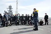 YN2 Thomas Jones demonstrates life preserver inflation during "abandon ship" drill aboard USS&nbsp;Makin Island&nbsp;(LHD-8).